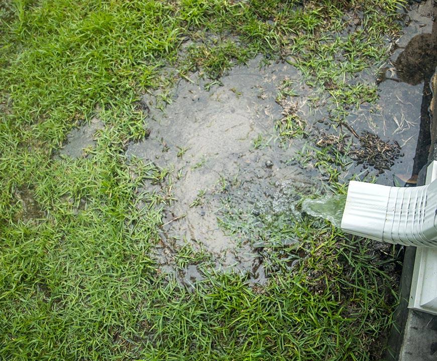 Yard flooding by gutter drain spout in need of a yard drainage system in Germantown, MD